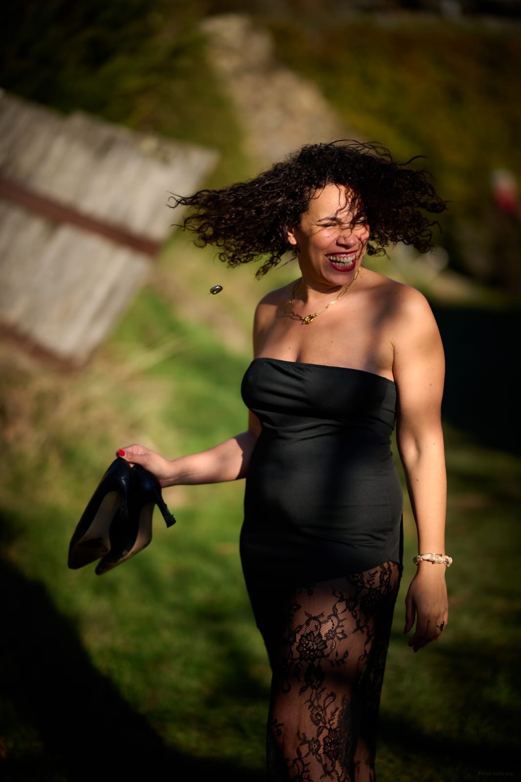 Laury riant, cheveux en mouvement, dans l'herbe